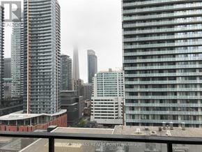 Toronto (Waterfront Communities) condo for rent - A cityscape with tall buildings and a cloudy sky.