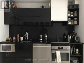 Toronto (Waterfront Communities) condo for rent - A black kitchen with a microwave, oven, and a black countertop.