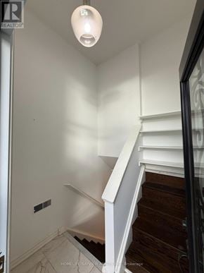Toronto (Victoria Village) apartment for rent - A white staircase with a black railing.