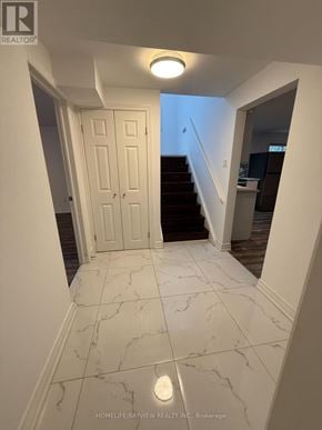 Toronto (Victoria Village) apartment for rent - A hallway with marble tiles and a white door.