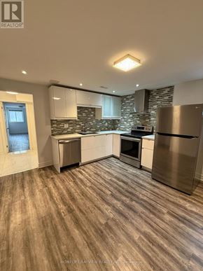 Toronto (Victoria Village) apartment for rent - A modern kitchen with wooden flooring and stainless steel appliances.