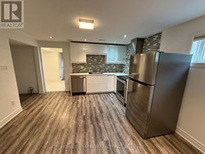 Toronto (Victoria Village) apartment for rent - A kitchen with a refrigerator, oven, and a countertop with a backsplash.