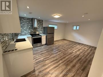 Toronto (Victoria Village) apartment for rent - A kitchen with a stove top oven and a refrigerator.
