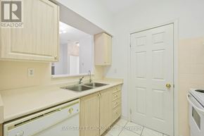 Toronto (Agincourt North) condo for rent - A kitchen with wooden cabinets and a white door.
