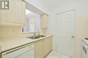 Toronto (Agincourt North) condo for rent - A kitchen with wooden cabinets and a white door.