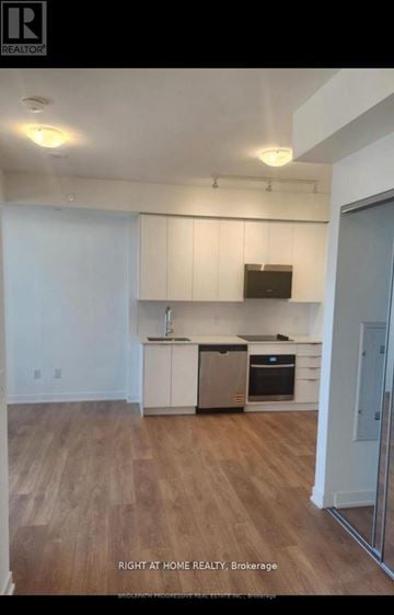 Vaughan (Concord) condo for rent - A kitchen with white cabinets and a wooden floor.
