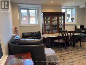 Markham (Grandview) apartment for rent - A living room with a black leather couch and wooden furniture.