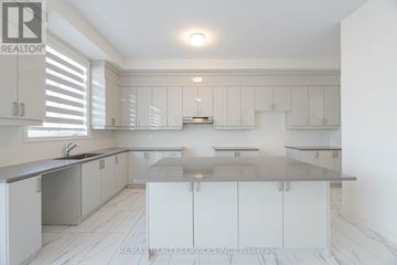 Adjala-Tosorontio (Colgan) apartment for rent - A modern kitchen with white cabinets and a central island.