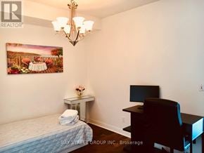 Toronto (Annex) condo for rent - A bedroom with a bed, desk, chair, and a painting on the wall.