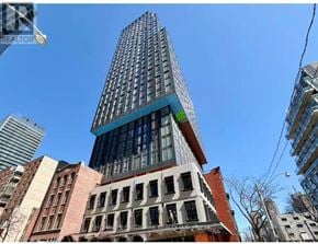 Toronto (Church-Yonge Corridor) condo for rent - A tall building with a blue glass top stands out against the sky.