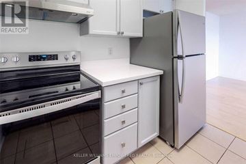 Toronto (Englemount-Lawrence) condo for rent - A kitchen with a stove top oven, white counter top, and a refrigerator.