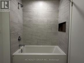 Mississauga (City Centre) condo for rent - A bathroom with a tub and a shower head.