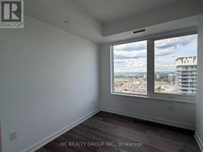 Mississauga (City Centre) condo for rent - A room with a large window overlooking a cityscape.