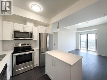 Waterloo condo for rent - A modern kitchen with white cabinets and stainless steel appliances.