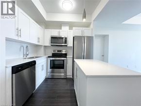 Waterloo condo for rent - A modern kitchen with white cabinets and stainless steel appliances.