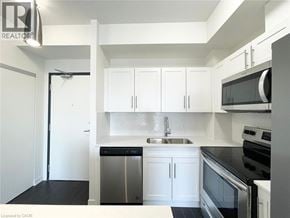 Waterloo condo for rent - A kitchen with white cabinets and black appliances.