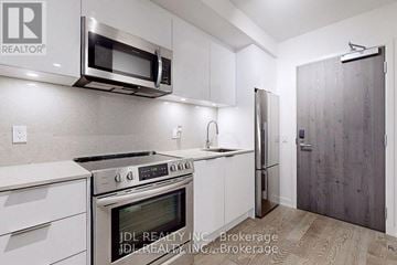 Toronto (Church-Yonge Corridor) condo for rent - A kitchen with white cabinets and stainless steel appliances.