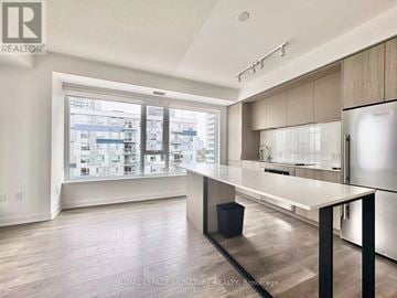 Toronto (Regent Park) condo for rent - A modern kitchen with a large island and a view of the city.