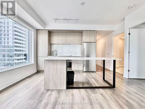 Toronto (Regent Park) condo for rent - A modern kitchen with a large island and a dining table.