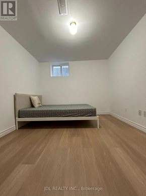 Toronto (Agincourt North) apartment for rent - A bedroom with a bed and wooden floors.