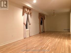Markham (Cachet) apartment for rent - A room with wooden floors and a window with curtains.