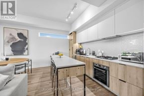 Toronto (Yorkdale-Glen Park) condo for rent - A modern kitchen with wooden cabinets and a dining table.