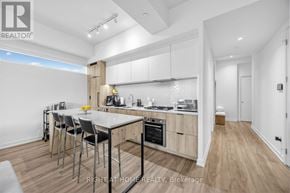 Toronto (Yorkdale-Glen Park) condo for rent - A modern kitchen with a dining table and chairs.