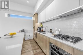 Toronto (Yorkdale-Glen Park) condo for rent - A modern kitchen with a stove top oven and a bowl of lemons on the counter.