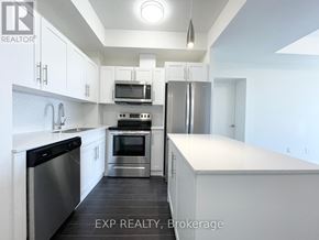 Waterloo condo for rent - A kitchen with white cabinets and stainless steel appliances.