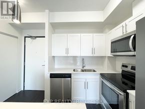 Waterloo condo for rent - A kitchen with white cabinets and black appliances.