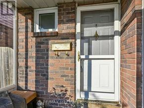 Oshawa (Donevan) apartment for rent - A white door with a gold handle is on a brick wall.
