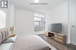 Toronto (Church-Yonge Corridor) condo for rent - A living room with a grey couch and a television on a wooden stand.