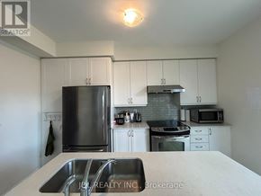 Toronto (West Hill) apartment for rent - A kitchen with white cabinets and a stainless steel refrigerator.