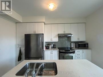 Toronto (West Hill) apartment for rent - A kitchen with white cabinets and a stainless steel refrigerator.