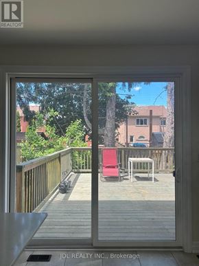 Toronto (West Hill) apartment for rent - A balcony with a table and chairs overlooks a backyard.