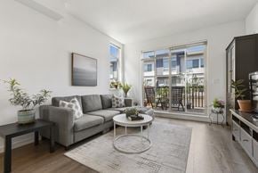 Surrey townhouse for rent - A living room with a grey couch, a coffee table, and a painting on the wall.