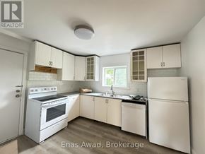 Ottawa multi-family for rent - A white kitchen with a refrigerator, oven, and sink.