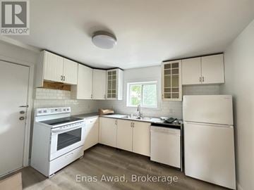 Ottawa multi-family for rent - A white kitchen with a refrigerator, oven, and sink.