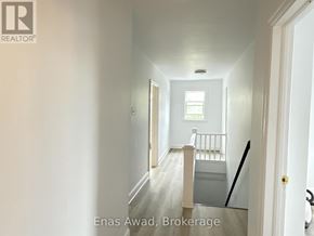Ottawa multi-family for rent - A hallway with a door on the right and a window on the left.