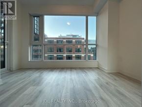 Toronto (Waterfront Communities) condo for rent - A spacious room with a view of a cityscape through large windows.