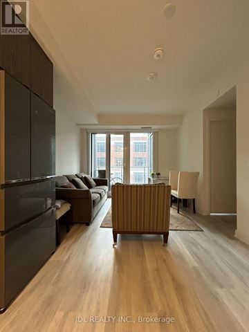 Toronto (Waterfront Communities) condo for rent - A modern living room with a dark wood floor and furniture.