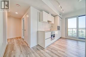 Toronto (Kensington-Chinatown) condo for rent - A well-lit kitchen with white cabinets and a wooden floor.