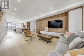 Toronto (Palmerston-Little Italy) apartment for rent - A living room with a grey couch and a wooden wall.