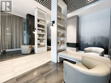 Oakville (Ro River Oaks) condo for rent - A modern living room with a white sofa and a glass cabinet.