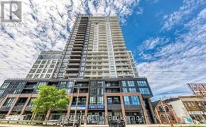 Toronto (East End-Danforth) condo for rent - A tall building with a glass facade and a sign that reads "REALTOR" is the main focus of the image.