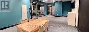 Toronto (East End-Danforth) condo for rent - A conference room with a table and chairs and a sign that says EXP REALTY Brokerage.