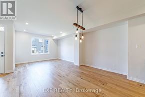 North Grenville townhouse for rent - A large, empty room with wooden floors and a chandelier.