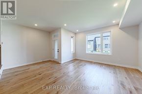 North Grenville townhouse for rent - A spacious room with wooden flooring and a large window.