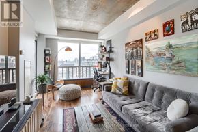 Toronto (Niagara) condo for rent - A living room with a grey couch and a large window.