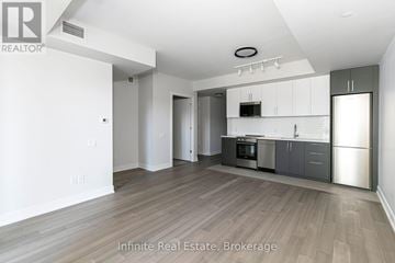 Toronto (University) condo for rent - A spacious kitchen with white cabinets and stainless steel appliances.